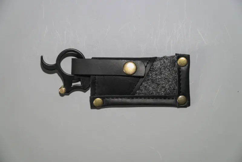 A mini straight razor with swappable blade and finger ring in a case