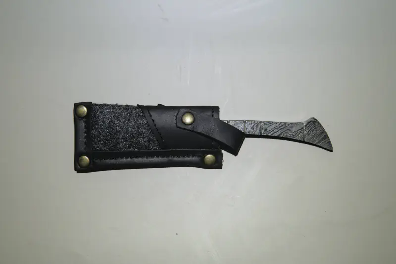 A straight handle damascus straight razor in a case